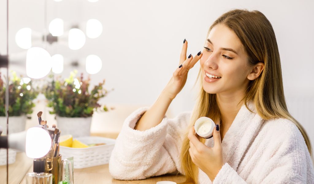 woman applying moisturizer on face